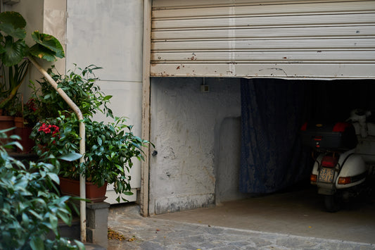 a moped parked next to a garage door