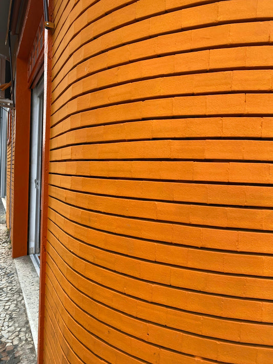 a building with a curved wooden wall on the side of it
