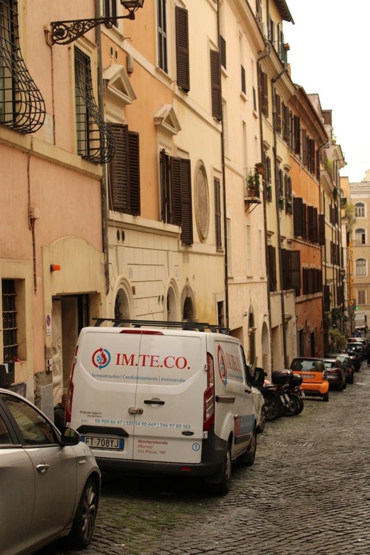 A row of parked cars on a cobblestone street