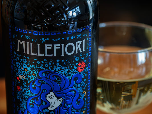 Millefiori wine bottle with a glass of wine.