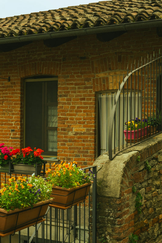 Brick building with flower boxes and a balcony.