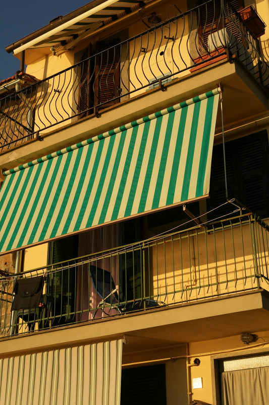 A green and white striped awning on a balcony.